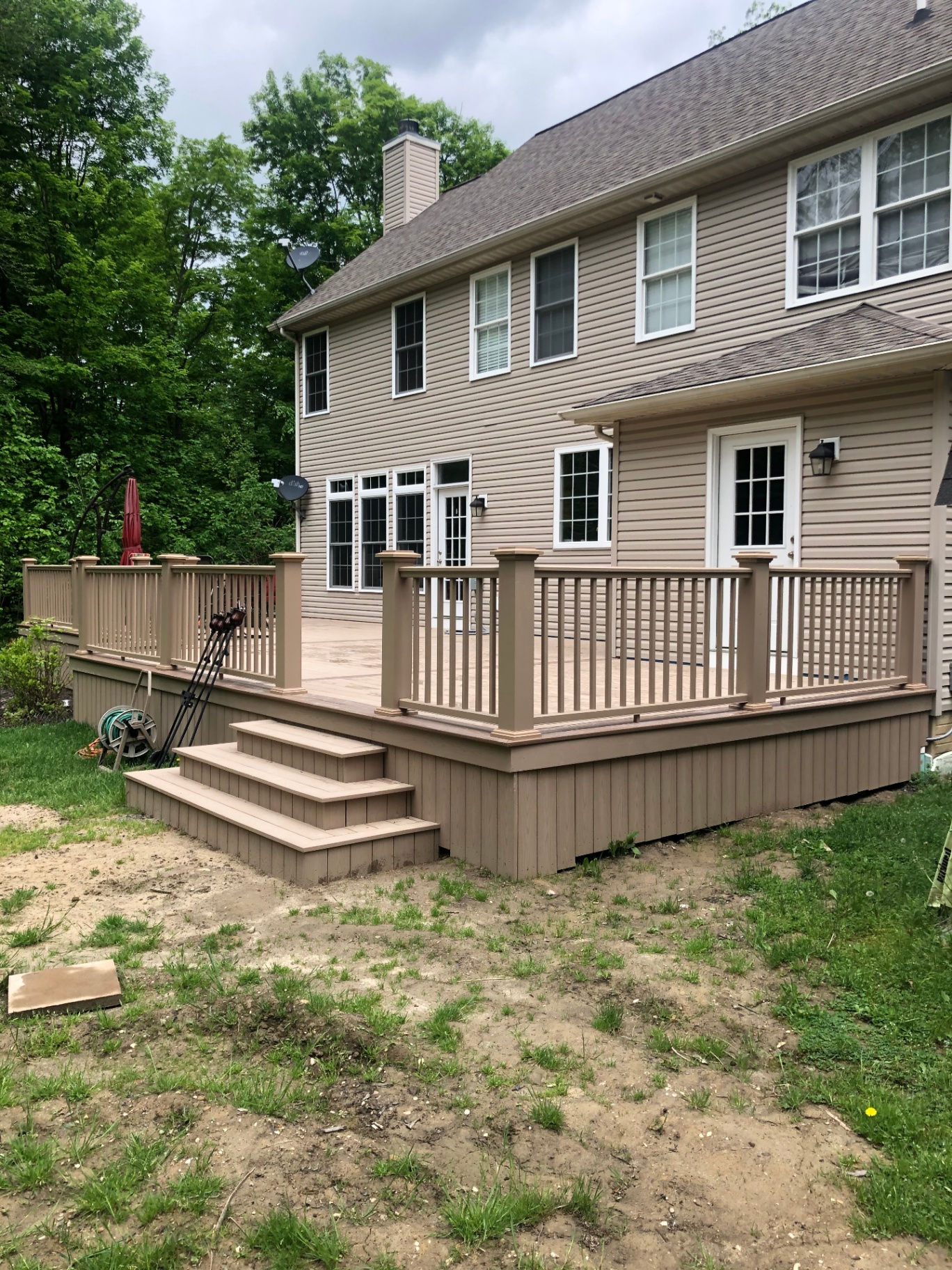 New composite deck with steps and matching railings on a colonial home
