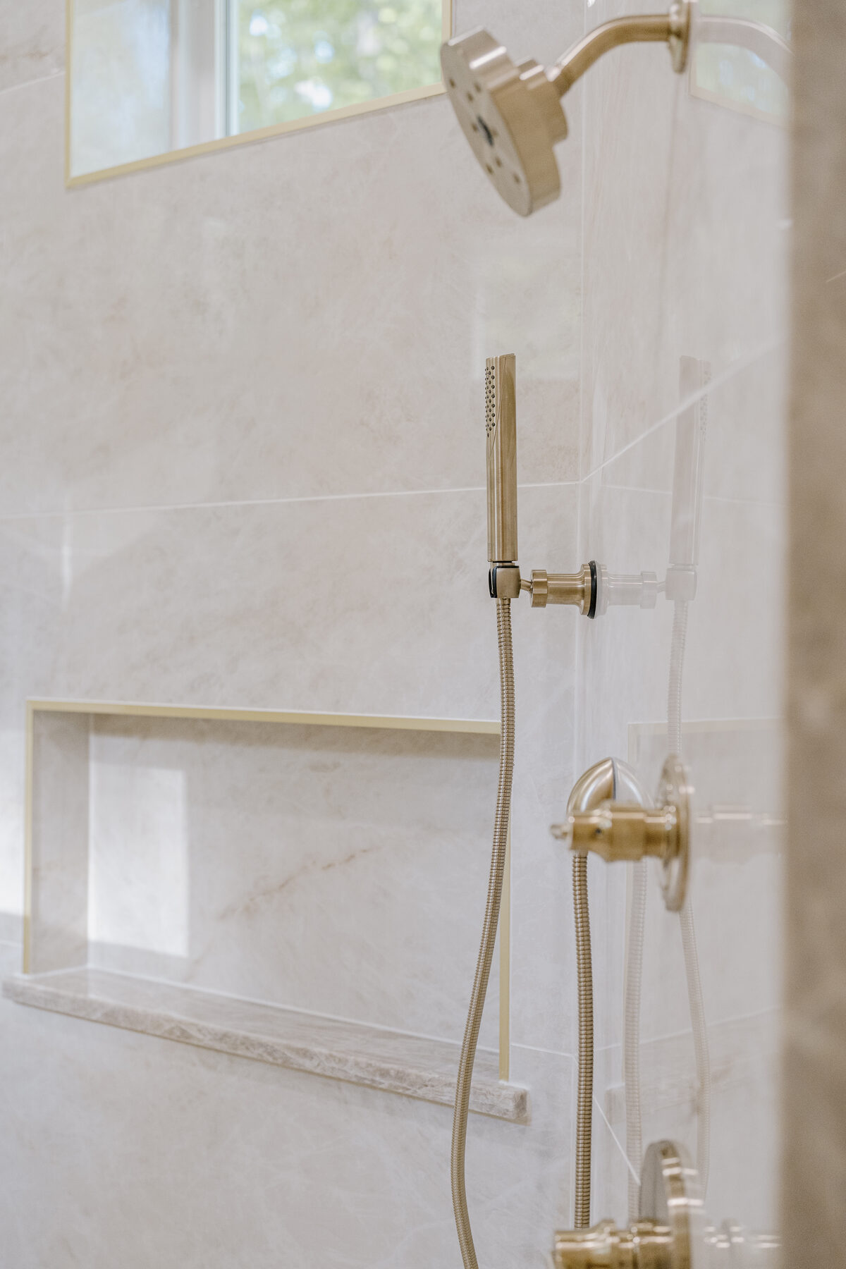 Walk-in shower with brass fixtures and marble surround