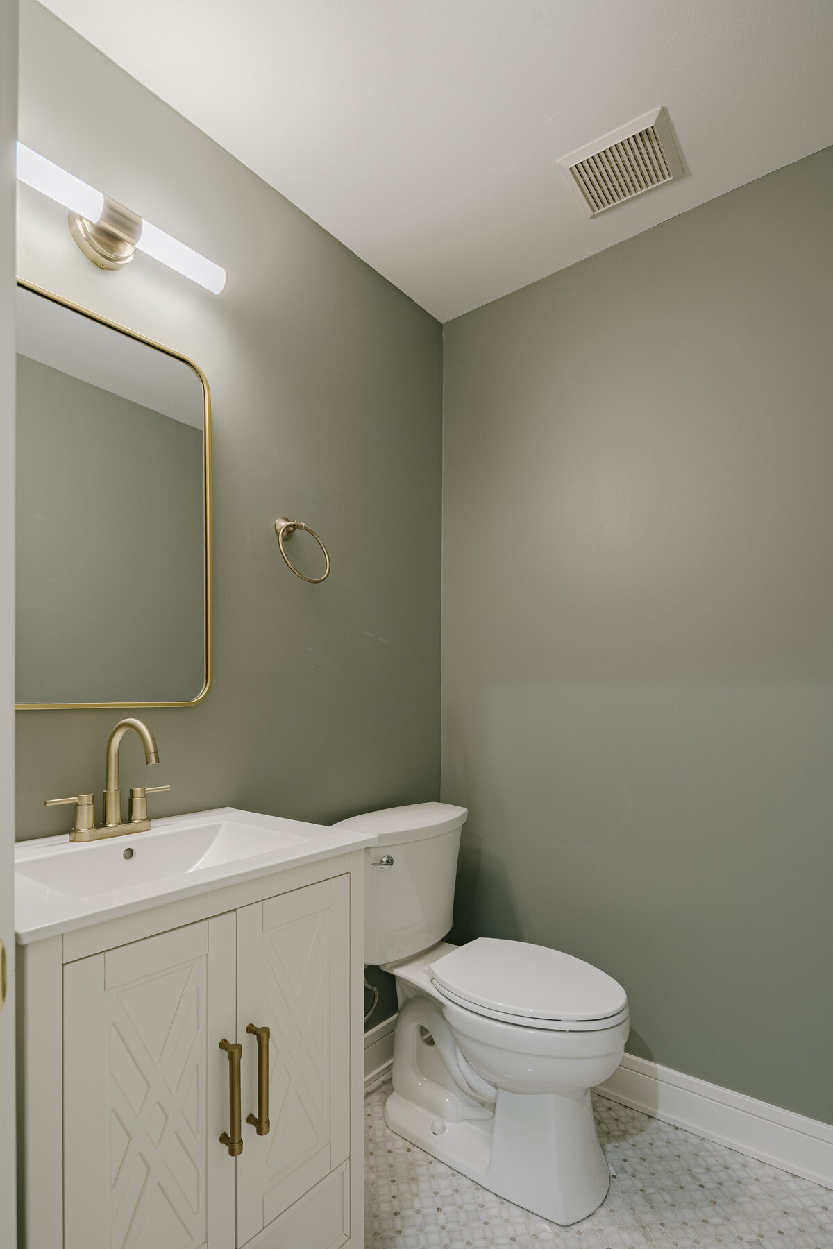 Powder room with gallery sconce and brass fixtures