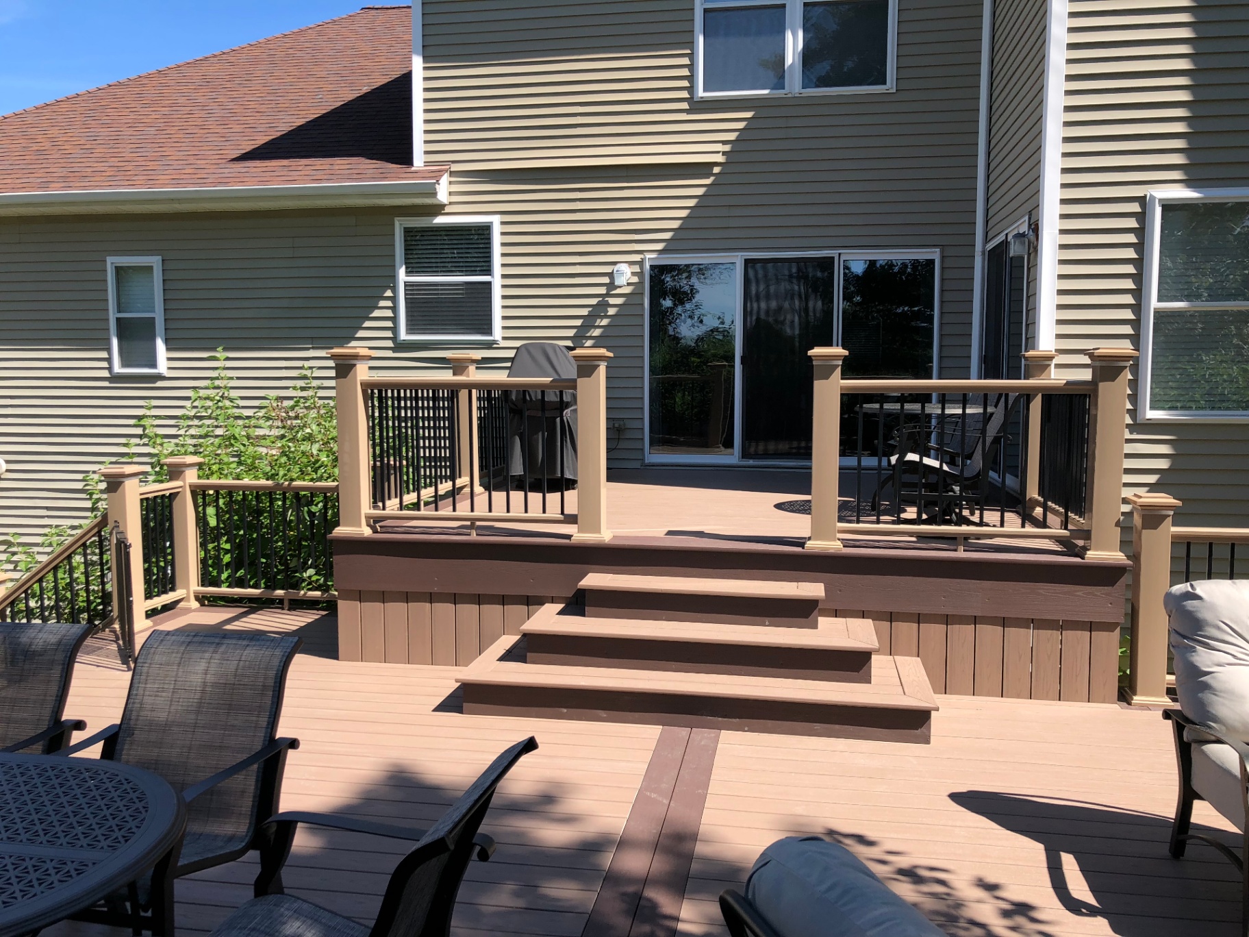 Multi-level composite deck with two-tone decking and metal balusters